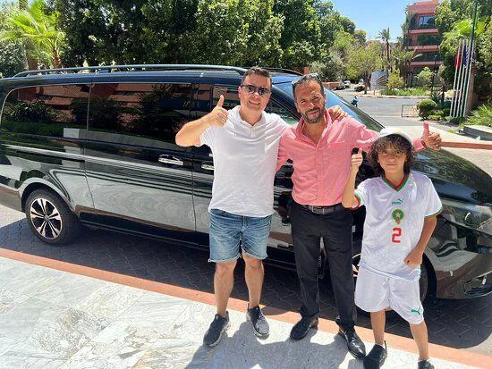 Guests beside a private tourist transport vehicle in Morocco